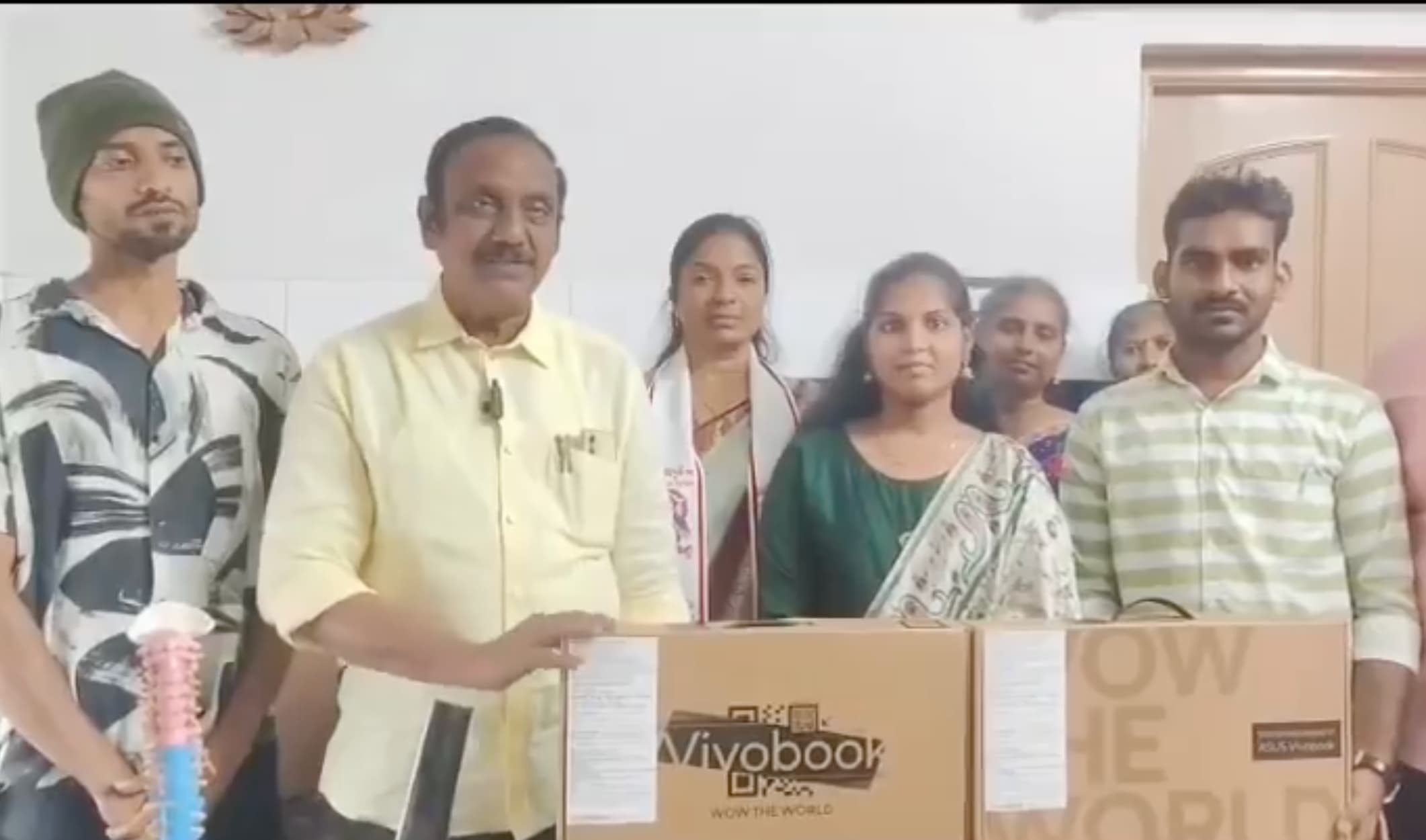 Student Anil Sai receiving a laptop at the Mangalagiri camp office