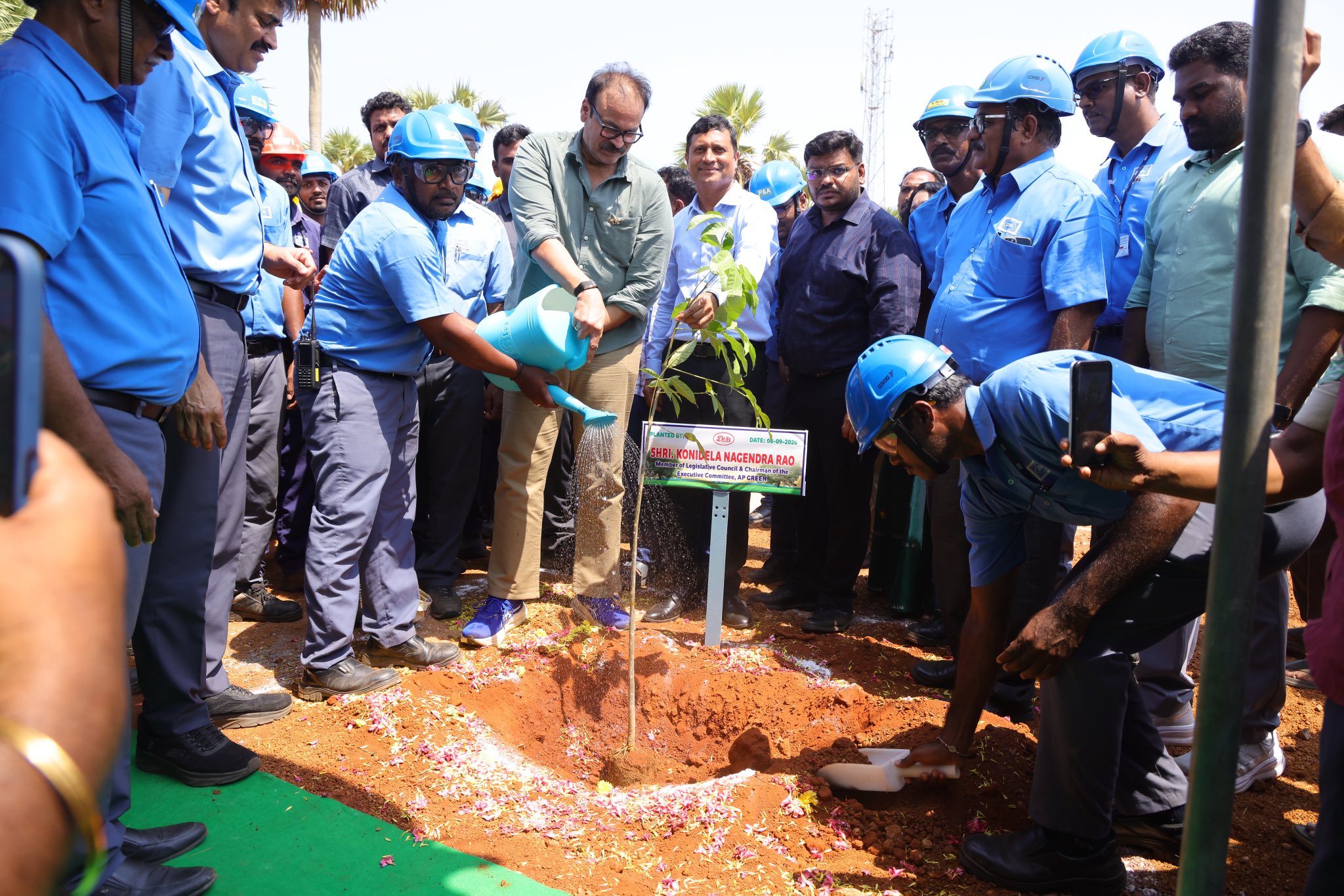 Naga Babu planting a sapling with Divi's Laboratories employees at the Ontimamidi facility