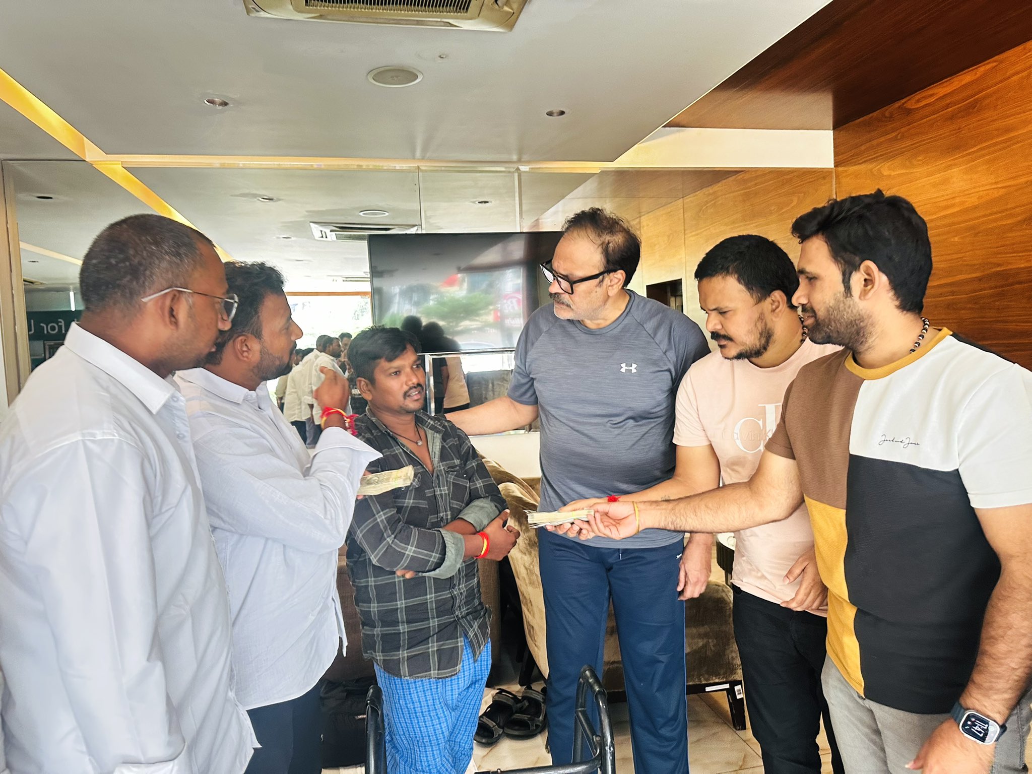 Jana Sainiks handing over ₹1.20 lakh financial aid to the family of auto driver Chepala Shivaji