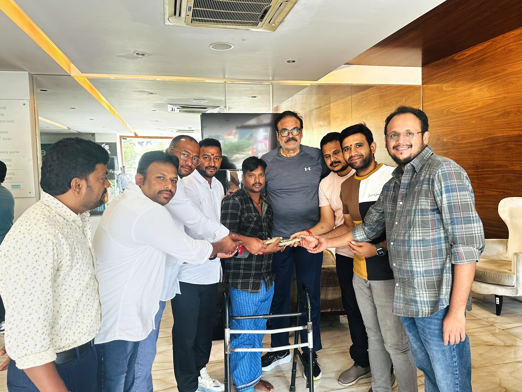 Jana Sena workers with the family of auto driver Chepala Shivaji during the financial support handover